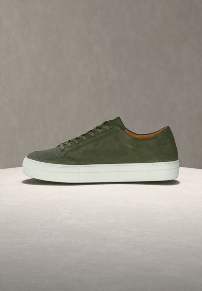 Πράσινο σουέντ αθλητικό παπούτσι με λεία υφή, λευκή καουτσούκ σόλα και μινιμαλιστικό σχεδιασμό. Διαθέτει επίπεδα κορδόνια και καφέ εσωτερικό.