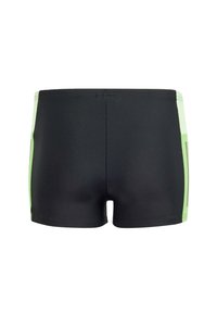 Pantaloni da nuoto neri con pannelli laterali verdi. Realizzati in un materiale liscio e elasticizzato. Design aderente con taglio a vita bassa e dettagli minimi.