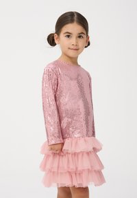 Abito rosa con paillettes, maniche lunghe e orlo di tulle arricciato. La parte superiore scintillante e la gonna a strati aggiungono volume e consistenza.