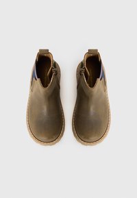 Botas de tornozelo em couro castanho com uma textura suave, painéis laterais elásticos em azul e vermelho, e uma sola embelezada em bege. Duas alças na parte de trás.