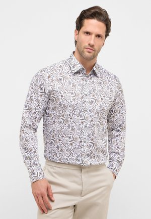 Langärmeliges Hemd aus weißem Stoff mit filigranen braunen Blumen- und abstrakten Mustern; verfügt über einen Kragen und eine Knopfleiste.