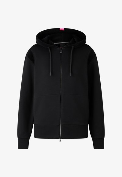 Sudadera negra con cremallera completa, con cordones, puños y dobladillo acanalados, y una pequeña etiqueta rosa en el centro de la parte posterior de la capucha.