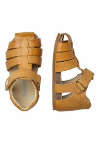 Bruna lädersandaler med fl ätad ovandel, öppna sidor, justerbar rem och platt sula. Har en vadderad innersula för komfort.