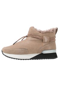 Bota de invierno beige tipo sneaker con parte superior texturizada, forro de pelo sintético, cordones envueltos, suela acolchada blanca y negra, y acento metálico en el talón.