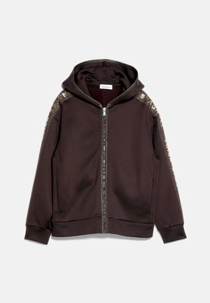 Sweat à capuche zippé marron avec bordure brillante le long de la fermeture éclair et des épaules, avec un texte imprimé sur les deux manches.