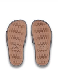 Hnědé gumové stélky sandálů s texturovanými podrážkami, které mají vlnité vzory, logo Quiksilver a tmavě šedé lemování.