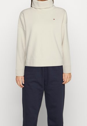 Crème turtleneck sweatshirt van zachte stof, met verlaagde schouders en geribbelde manchetten. Beschikt over een klein logo op de linkerborst.