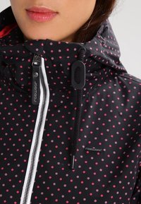 Černá bunda s růžovými puntíky, se zipovým zapínáním vpředu, kapucí se šňůrkami a černými akcenty. Texturovaná látka s hladkým povrchem.