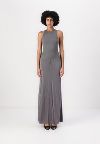 Robe maxi grise avec un haut ajusté et une jupe fluide décontractée. Fabriquée en tissu doux, elle dispose d'une taille élastique et d'un col rond.