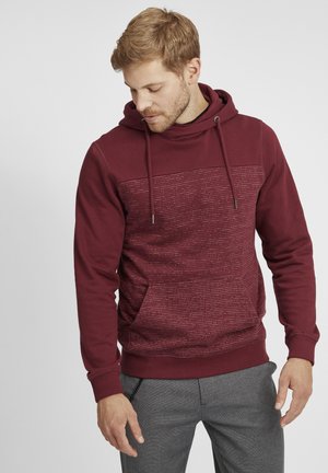 Maroon hoodie featuring a textured front panel, drawstrings, and a kangaroo pocket. Soft fabric with ribbed cuffs.