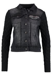 Mustat farkkutakki, jossa on kaapelikudotut pitkät hihat, napit edessä, kaksi rintataskua ja ommeltu yksityiskohtia saumoissa.