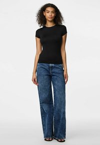 Sorte kortærmede top parret med højtaljede, vide blå denim jeans. Stoffet er glat, med en tætsiddende silhuet og et minimalistisk design.