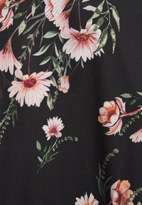 Květinová textilie s velkými růžovými sedmikráskami a oranžovými květy na černém pozadí, s prokládanými zelenými listy a stonky.