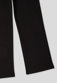 Leggings neri realizzati in un morbido tessuto elasticizzato, caratterizzati da una vestibilità slim e un taglio dritto. I dettagli delle cuciture lungo le gambe migliorano il design.