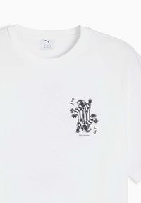 Hvid Puma T-shirt med sort-hvide stribede tiger grafik, der holder fodbold, bogstaverne P og D, samt teksten "Play smarter" på brystet.