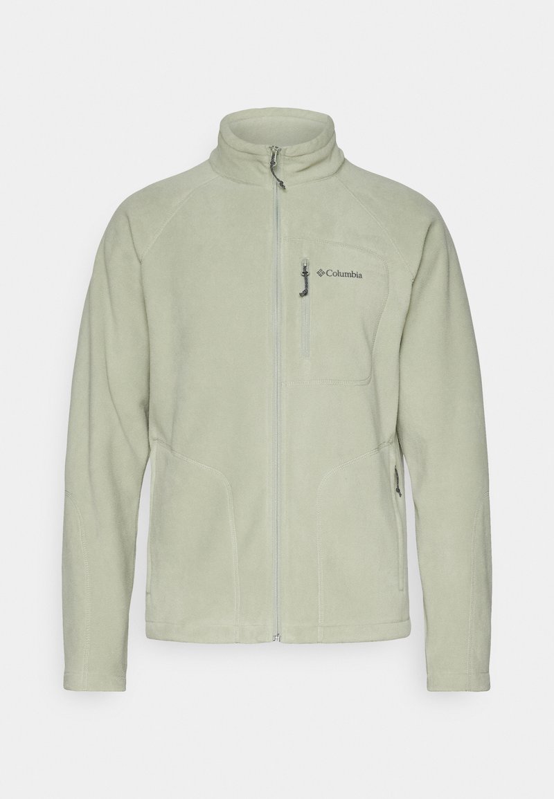 Chaqueta de forro polar verde claro con cuello alto, cremallera frontal y dos bolsillos laterales. Presenta el logo de Columbia en el lado izquierdo del pecho y una textura suave.