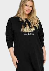 Crna haljina od dukserice s dizajnom božićnog drvca od zlatnih šljokica i tekstom "Sretan Božić" u bijeloj boji, s rebrastim manžetama i opuštenim krojem.