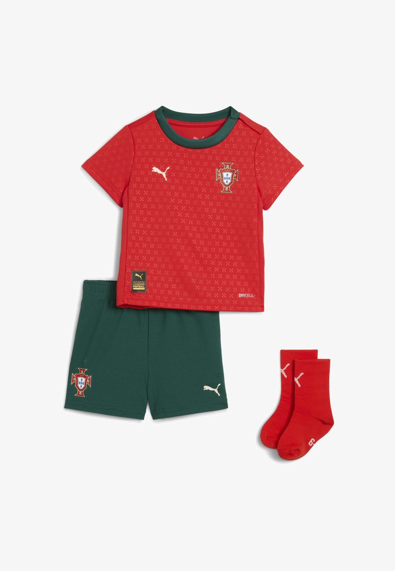 Červená košile s krátkým rukávem a zeleným límcem, se znakem Portugalska a bílým logem. Zahrnuty jsou také zelené šortky a červené ponožky, vše vyrobeno z měkké tkaniny.