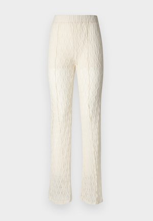 Pantaloni in pizzo color crema con un tessuto strutturato e decorato. Presentano una vita liscia e gambe svasate, sottolineando un design leggero.
