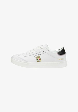 Weiße Ledersneaker mit einem Teddybär-Graphic, grünen, roten und gelben Details sowie einem schwarzen Akzent an der Ferse. Limitierte Auflage Text enthalten.