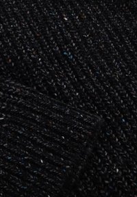 Close-up van zwart gebreide stof met meerkleurige spikkels, met zichtbaar getextureerd ribbelpatroon en duidelijke stikdetails.