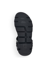 Semelle de sandale en caoutchouc noir avec des motifs texturés pour l'adhérence, comportant des découpes et une empreinte de logo. Design plat avec un matériau résistant.