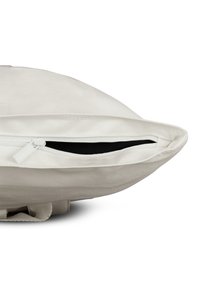 Fehér szövetpárna, részlegesen nyitott cipzárral, amely felfedi a fekete belső szövetet, fehér háttér előtt.