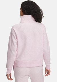 Sudadera rosa claro con un alto cuello, mangas raglán y puños y dobladillo de canalé. Tela suave con un acabado texturizado.