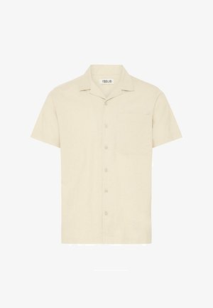 Košile s krátkým rukávem a límečkem ze světle béžové tkaniny, s přední kapsou a zapínáním na pět knoflíků.