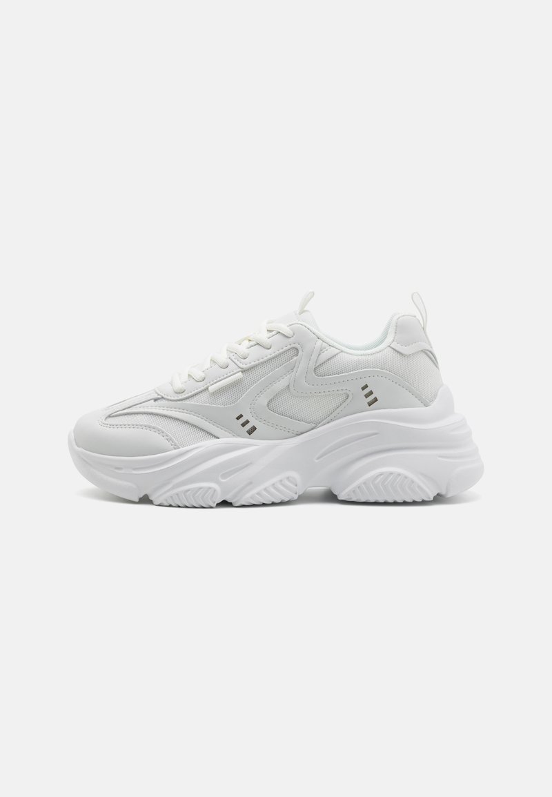 White athletic shoes with a textured upper, padded tongue, and chunky sole. Design features include curved lines and small accents on the sides.