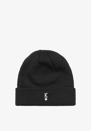 Svart stickad mössa med uppvikt design, med en vit broderad logotyp "K" med ett spade-motiv. Strukturerad tyg.