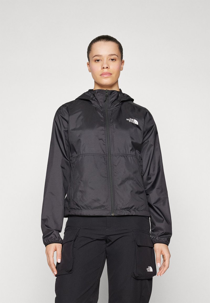 Crna lagana jakna s kapuljačom, prednjim patentnim zatvaračem, rastezljivim manžetama i logotipom The North Face na lijevoj strani prsiju; glatka, vodootporna tkanina.