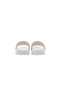 Sandali con una suola bianca liscia, design aperto e morbidi cinturini color beige. Presentano una tomaia testurizzata con una leggera lucentezza. Stile minimalista.