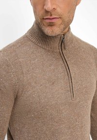 Brauner Pullover mit Reißverschluss aus strukturiertem Strickmaterial, ausgestattet mit einem gerippten Kragen und orangefarbenen Sprenkeln im Stoff.