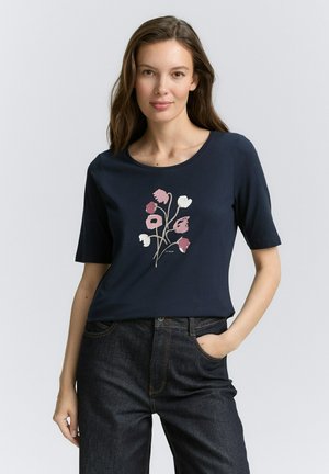 T-shirt bleu marine à manches courtes avec un motif floral en rose, crème et vert. Fabriqué à partir d'un matériau doux ; coupe décontractée et relaxée.