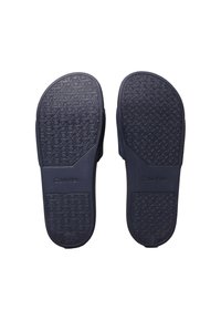 Plantillas de goma de color azul marino con un diseño de suela patrón y la marca "Calvin Klein". Diseño de borde liso con una forma contorneada.