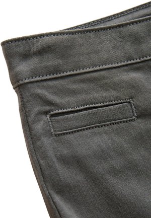 Tessuto di denim grigio con una texture liscia, dotato di una tasca posteriore e cuciture a contrasto lungo il bordo della vita e della tasca.