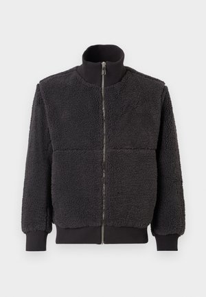 Schwarze Fleecejacke mit hohem Kragen, Frontreißverschluss und gerippten Ärmelbündchen. Sie hat eine strukturierte, flauschige Oberfläche und eine lässige Passform.