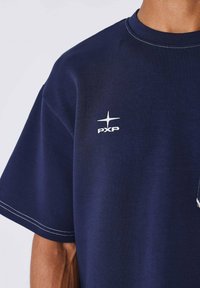 Navyblauwe T-shirt van katoen, met een ronde hals en korte mouwen, voorzien van witte stiksels en een klein gedrukt logo op de borst.
