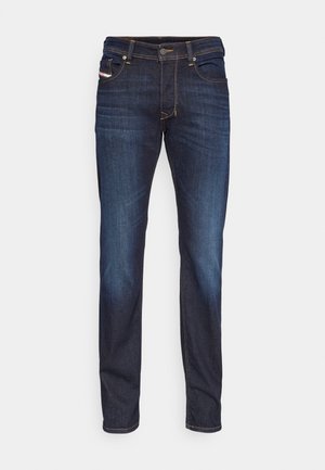 Slim-fit dark blue jeans with orange stitching, front button and zipper, and five-pocket design, laid flat on a white background.