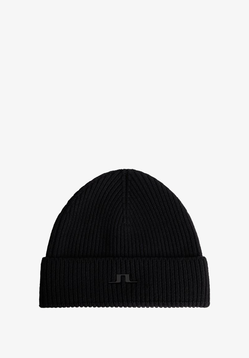 Svart stickad mössa med ribbat mönster, med en vikbar kant och en liten svart logomarkering på framsidan.