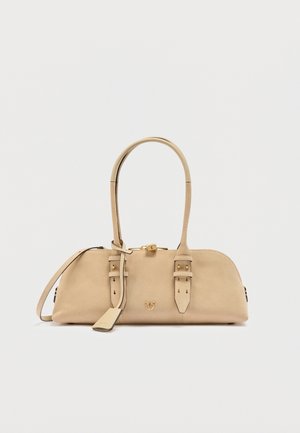 Beige læderhåndtaske med to top-hanke, spænde-detaljer, en lille guldlokale og lynlås lukning på en hvid baggrund.