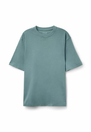 Korte mouwen t-shirt van zachte, turquoise katoen. Heeft een ronde halslijn en een ongepaste vorm met een relaxte pasvorm. Soepele textuur.