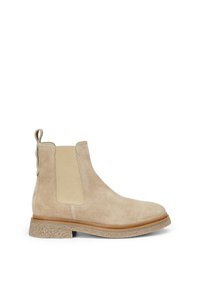 Bottine Chelsea en daim beige avec panneaux latéraux élastiques, languette de tirage, semelle en cuir marron et semelle extérieure en caoutchouc texturé.