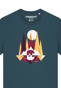 Teal t-shirt met een grafisch ontwerp van een beer op een ijsberg, omringd door kleurrijke geometrische bomen en een grote gele maan.