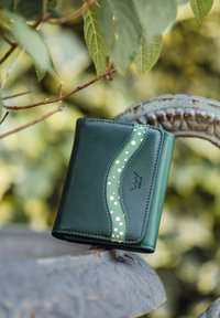 Green leather wallet featuring a wave design with white polka dots. Smooth texture, compact shape, and embossed brand logo detail.