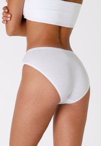 Mutande bianche di cotone con una texture liscia, design a vita bassa e fascetta elastica, che mostrano uno stile semplice e senza cuciture.