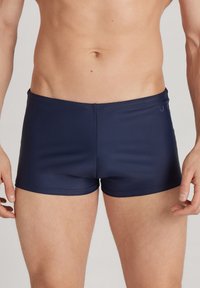 Dunkelblaue Schwimmshorts mit einem enganliegenden Design, aus glattem, dehnbarem Material gefertigt. Verfügt über einen schlichten Bund und ein minimalistisches Logodesign.