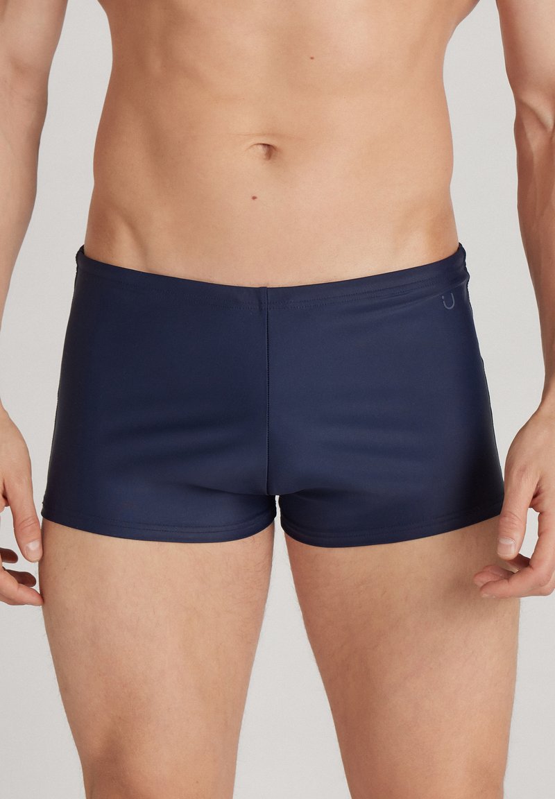Dunkelblaue Schwimmshorts mit einem enganliegenden Design, aus glattem, dehnbarem Material gefertigt. Verfügt über einen schlichten Bund und ein minimalistisches Logodesign.