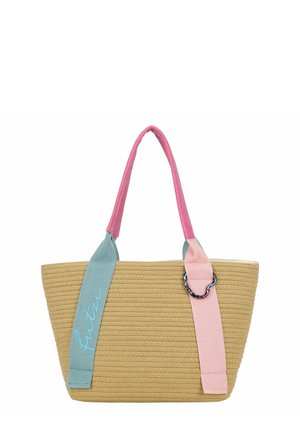 Geweven beige draagtas met brede roze en blauwe handvatten, een blauwe riem met het woord "futva" geborduurd en een decoratieve multicolor ring aan de roze riem.